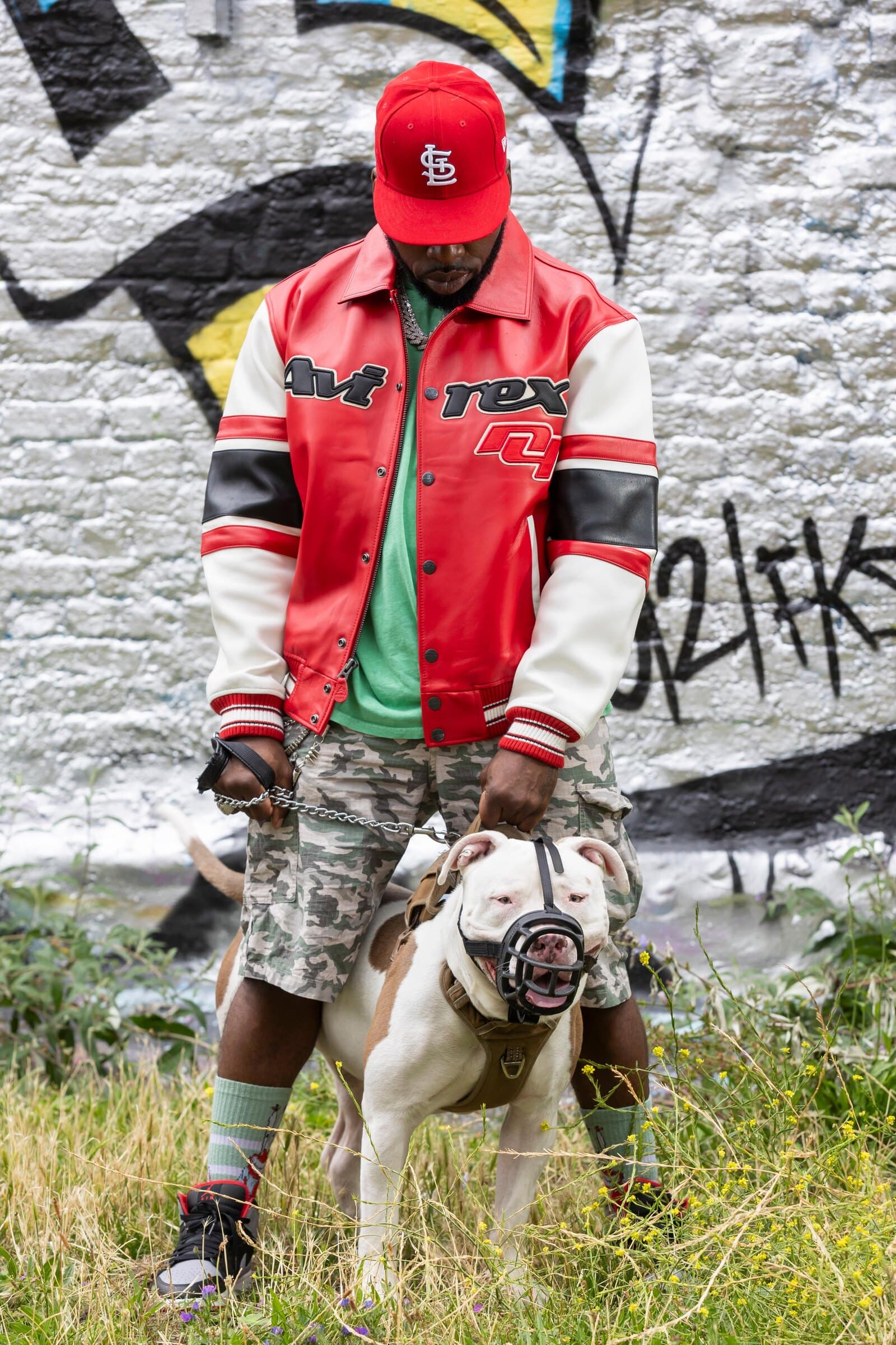 Vic Santoro with his dog in front of graffiti