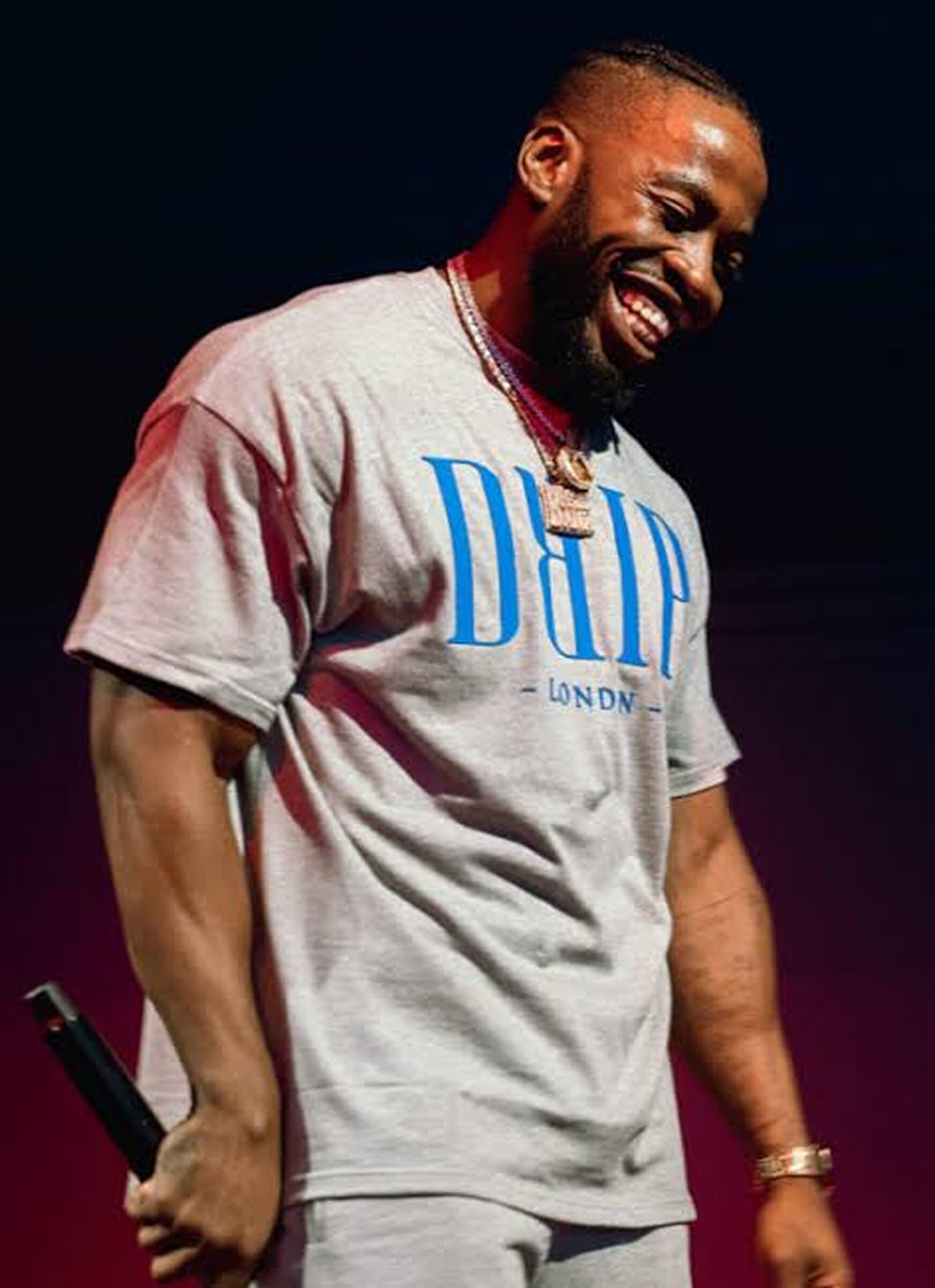 Vic Santoro smiling on stage in a Drip London t-shirt