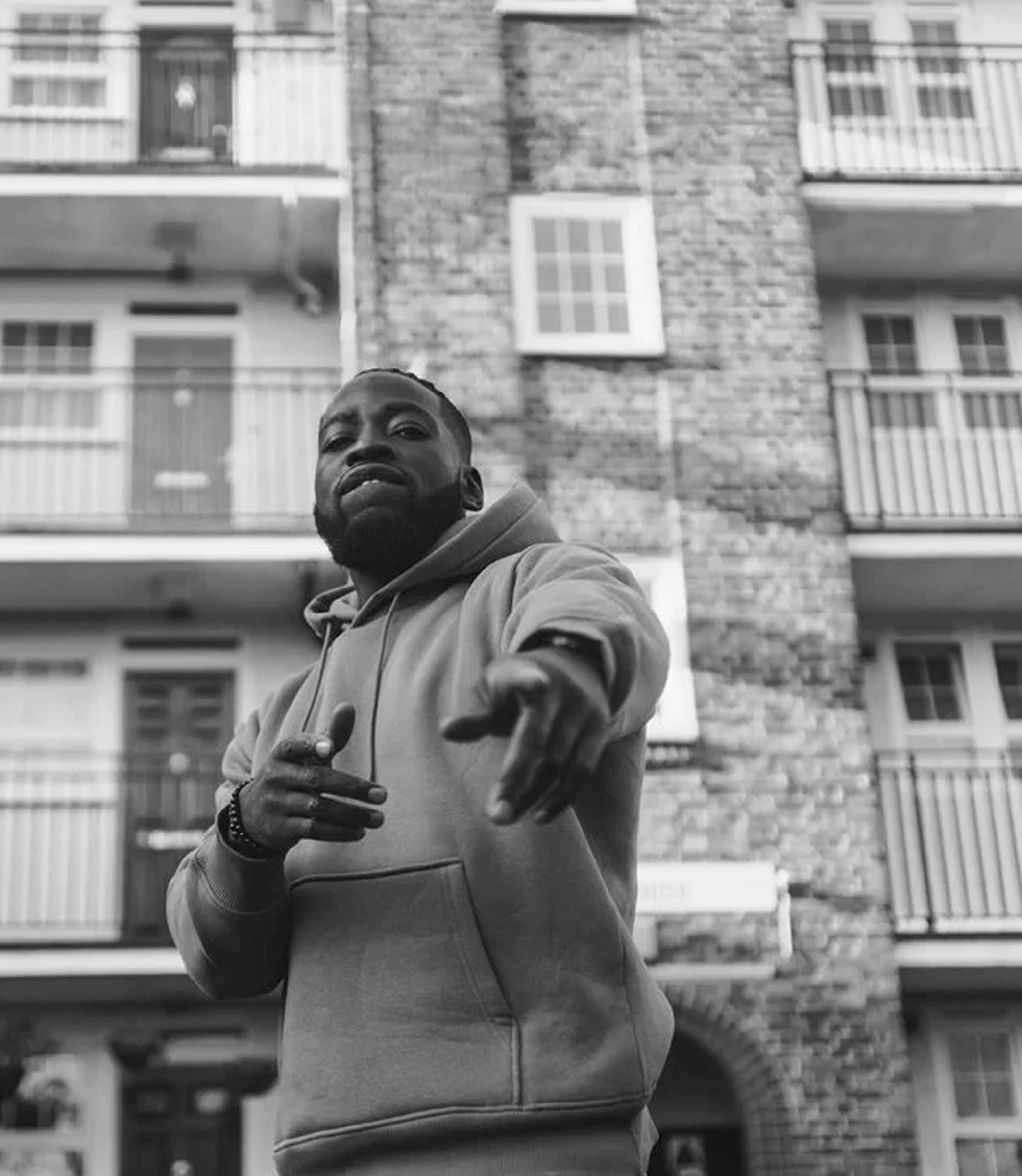Vic Santoro in a hoodie outside a London estate